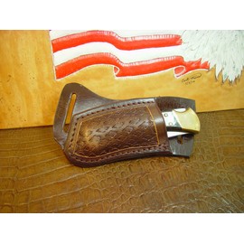 Custom left hand cross draw knife sheath for a buck 110 knife. The sheath is made out of buffalo hide leather hand tooled with a basket weave pattern.
