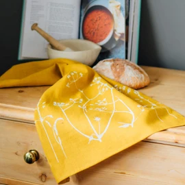 Mustard Linen Tea Towel, hand printed with hedgerow flowers. This beautiful 100% linen tea towel is machine washable at 40 degrees and will compliment your kitchen decor perfectly. Size 70 x 46cm