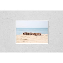 Poster Reproduction of Vacation word on wood rubber stamps stack on the sand beach for holiday and summer season concepts, beautiful blue ocean view during daytime on a sunny day on background