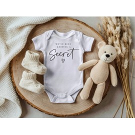 Surprise Pregnancy Announcement Infant Bodysuit - We've Been Keeping A Secret - New Baby Reveal Gift for Friends and Family (White)