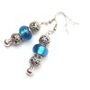 Ohrringe Charms Thurcolas Modell Manhattan mit Metallperlen und blauem Glas.