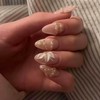 Uñas postizas medianas almendradas, color rosa nude con flores blancas