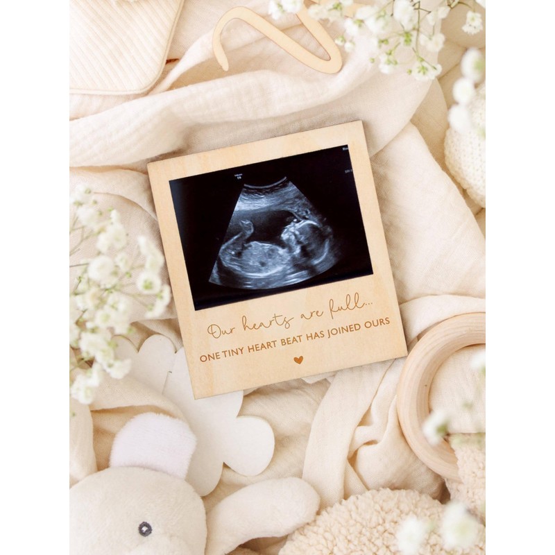Joli Coon Pregnancy announcement with wooden frame for the ultrasound